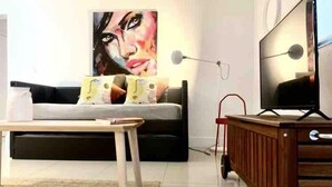 Una sala de estar moderna con un sofá, una mesa de centro, un televisor y un mueble de madera.