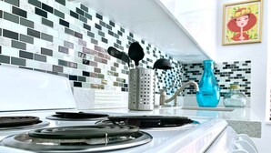 Cocina moderna con estufa blanca, salpicadero blanco y negro y un florero azul sobre la encimera.