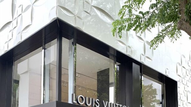 Un negozio Louis Vuitton con una facciata moderna e ampie vetrine in vetro.