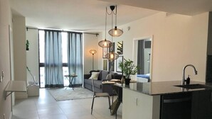 A modern apartment with a kitchen, dining area, and living room.