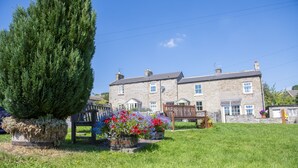 A stone house with a large lawn, a wooden fence, and flower beds. - Witton View, Bellerby, Yorkshire Dales (Leyburn)