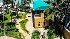 Ein Resort mit Poolbereich, Palmen und Meerblick.