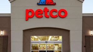 Un magasin Petco avec une grande enseigne rouge et un logo représentant un chat bleu et un chien rouge.