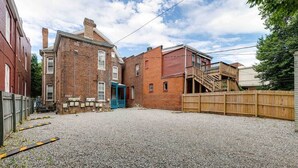 A residential area with a gravel driveway, a blue door, and a wooden fence.