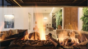 A cozy living room with a fireplace, two sofas, and a dining area in the background. - Moon (Binz)