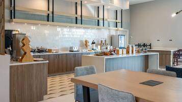 Une cuisine moderne dotée d’un îlot central, de meubles en bois et d’un coin repas avec une table et des chaises.