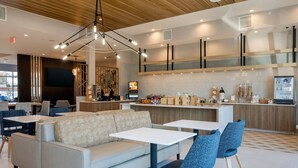 A modern lounge area with sofas, tables, and a bar counter.