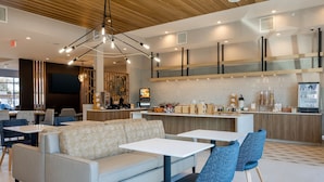 A modern cafe with a sofa, tables, and chairs.
