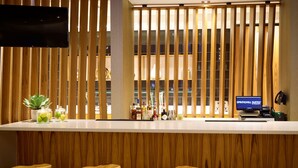 Un espace bar avec des lambris en bois, un téléviseur à écran plat et des tabourets.
