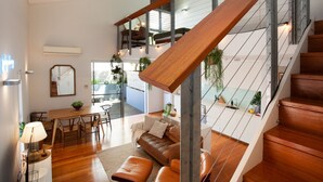 Um interior moderno com escada de madeira, área de jantar e sala de estar.