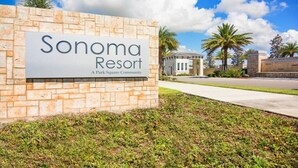 Naamplaatje voor Sonoma Resort, met een bakstenen muur en heldere lucht.
