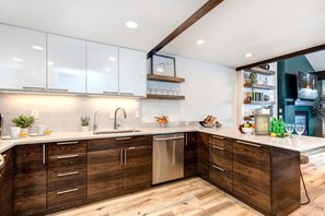 A modern kitchen with white cabinets, a wooden accent wall, a built-in dishwasher, and a wooden countertop. - KBM Resorts | Aspen Grove | Between Deer Valley and Main St, Awesome views with a Hot Tub, A/C for summer! AGC-8 (Park City)