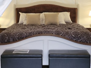 Un lit avec une couvre-lit à motifs, deux oreillers et une tête de lit.