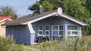 A small, single-story house with a sloped roof, a chimney, and a satellite dish. - Freibeuterweg 2 - Dorf 6 (Lübeck)