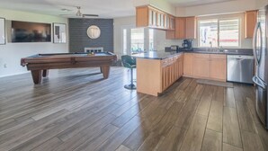 Eine moderne Küche mit Holzausstattung, einer zentralen Kochinsel und einem eingebauten Backofen.