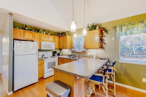 Enjoy cooking in this well-equipped kitchen with a central island, oven, and sink.