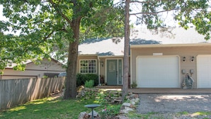 A residential house with a garage, a front yard with a tree, a bird feeder, and a gravel driveway. - Sunrise Bluff Lakefront - in family-friendly area w/ great view of Grand Lake (Grove)