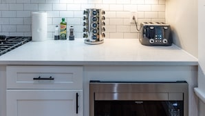 A kitchen with a stainless steel oven, a toaster, and a spice rack.