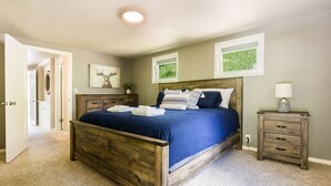 Un dormitorio con cama de madera, una mesita de noche y una lámpara de pared.