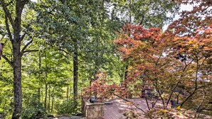 A wooden deck surrounded by trees with green and red foliage, indicating a natural setting. - Peaceful Nashville Hideaway Near State Parks! (Nashville)