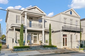 A two-story building with a balcony, a front entrance, and a small porch area. - Stunning 2BR | Balcony | Historic Luxury (New Orleans)