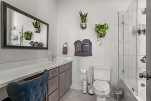 A modern bathroom with a large mirror, a toilet, a sink, and a shower. - Stunning 2BR | Balcony | Historic Luxury (New Orleans)