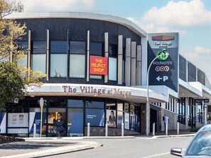 A modern building with a sign for 'The Village at Marks' and a Woolworths store.