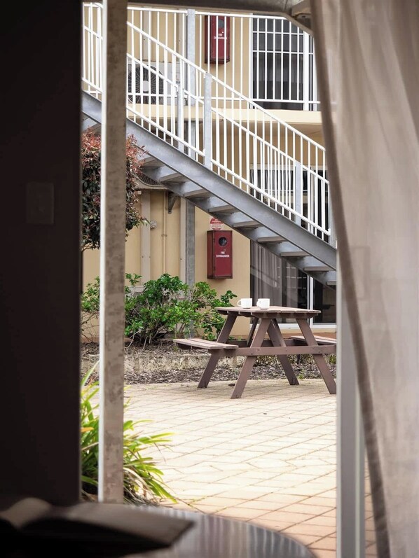 An outdoor area with a staircase, a fire extinguisher, and a picnic table.
