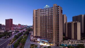Un hotel moderno de gran altura con un letrero llamativo en la parte superior.