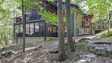 A modern house with large windows, a deck, and a stone pathway.