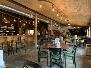 Un restaurante acogedor con techos de madera, conductos expuestos y un árbol de Navidad.