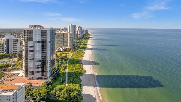 A coastal cityscape with high-rise buildings, a beach, and a clear sky. - Limited-Time Summer Deal on Lovely 2BR Condo with Tennis (naples)
