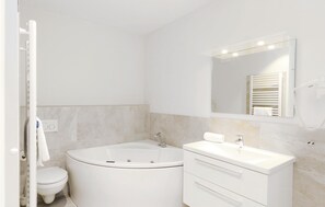 A modern bathroom with a freestanding bathtub, a white sink, and a large mirror. - Promenadenvilla (Lübeck)
