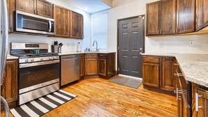A kitchen with wooden cabinets, stainless steel appliances, and a wooden floor. - Huge 6Bd House Historic Updated King Bed Shaw (St. Louis)