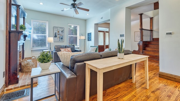 A spacious living room with a brown leather sofa, a wooden coffee table, and a ceiling fan. - Huge 6Bd House Historic Updated King Bed Shaw (St. Louis)