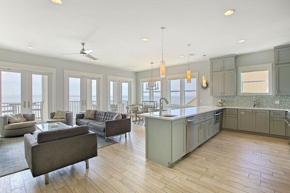 A spacious kitchen with a large island, modern appliances, and a view of the ocean. - Beaux Soleil - Stunning & Modern Beachfront Luxury Home! (Destin)