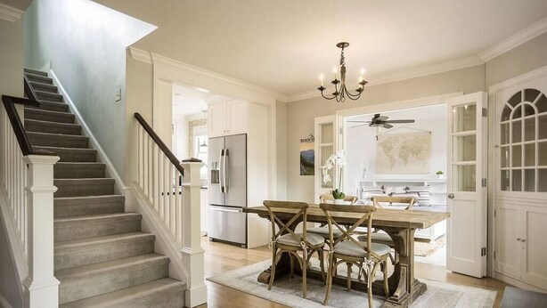 A spacious kitchen with a dining area, a staircase, and a large window. - West Boulevard Hideway (Rapid City)
