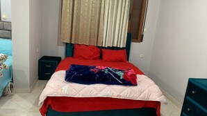 Une chambre à coucher avec un lit, une table de chevet, une commode et un tapis rouge.