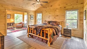 Un dormitorio de cabaña de madera con cama, escritorio y silla.