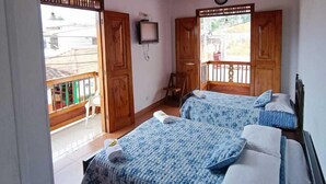 A room with two beds, wooden ceiling, and a TV on the wall. - Hotel Monte Verde (Salento)