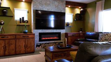 Smart TV, chimenea, libros y monitor de computadora