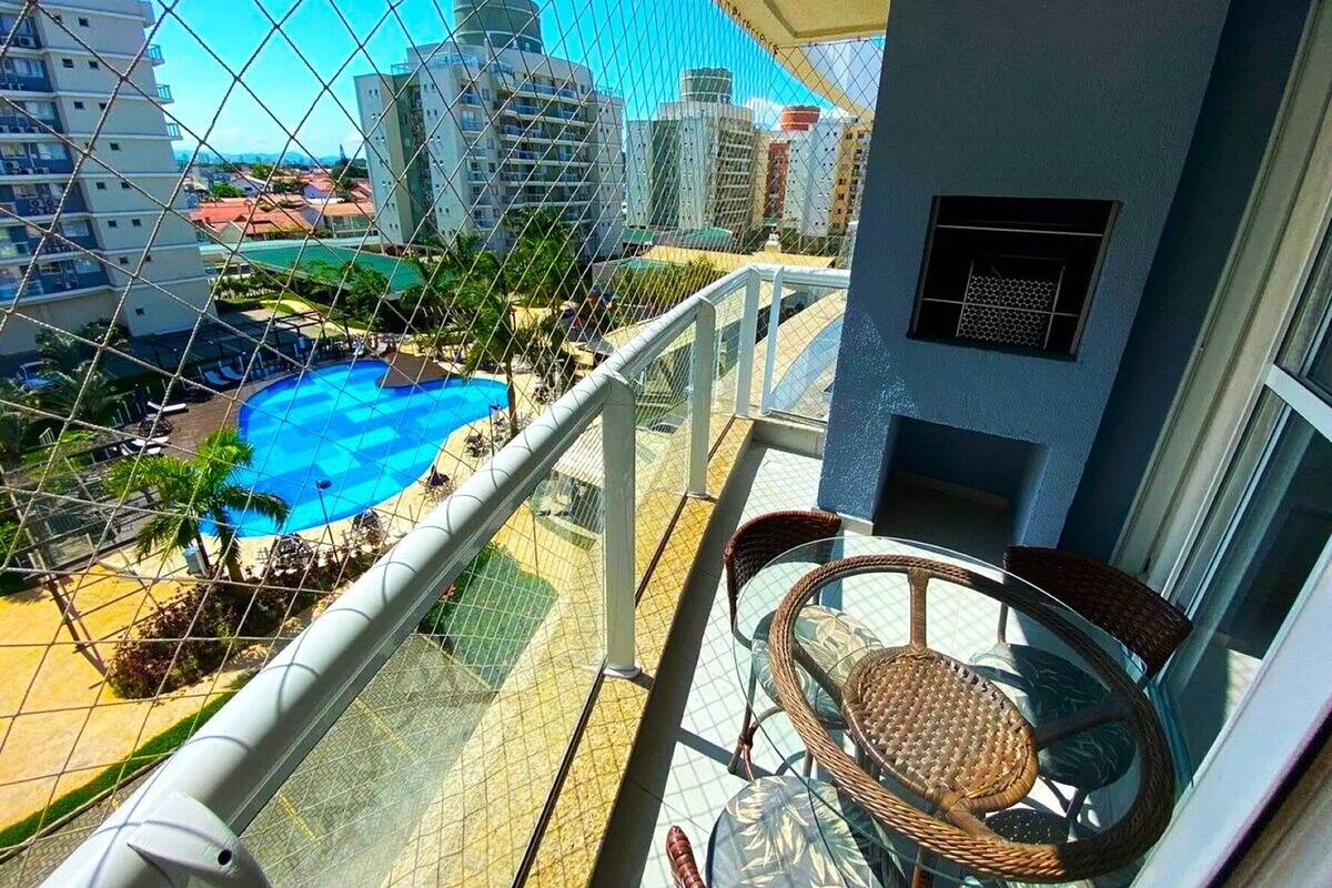 Varanda com vista para uma piscina e edifícios próximos.