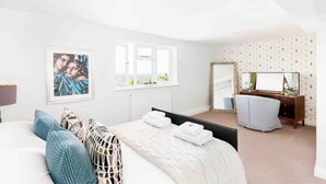 Ein Schlafzimmer mit einem Bett, einer Kommode, einem Spiegel und einem gerahmten Bild an der Wand.