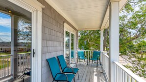 A covered porch with a railing, two chairs, and a table. - Beachside Home • Fenced Yard • Dogs Welcome (Norfolk)