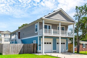 A two-story house with a balcony, a garage, and a fenced yard.