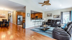 A spacious living room with a leather sofa, a coffee table, and a ceiling fan. - Beachside Home • Fenced Yard • Dogs Welcome (Norfolk)