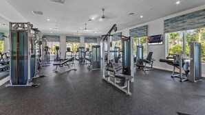A spacious gym with various exercise machines, large windows, and a modern ceiling design. - 10BR Villa Near Disney, Pool and Resort Waterpark (Kissimmee)