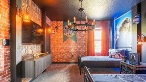 A room with a brick wall, a bed, a desk, and a chandelier. - 10BR Villa Near Disney, Pool and Resort Waterpark (Kissimmee)