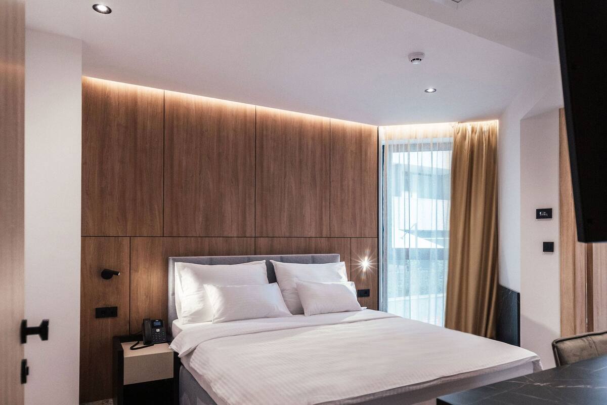 Ein modernes Hotelzimmer mit einem großen Bett, einem Schreibtisch und einem Fernseher.