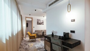 Ein modernes Hotelzimmer mit Essbereich, einer Couch und einem Couchtisch.